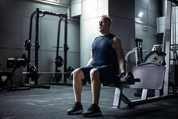Middle-aged man lifting dumbbells at the gym